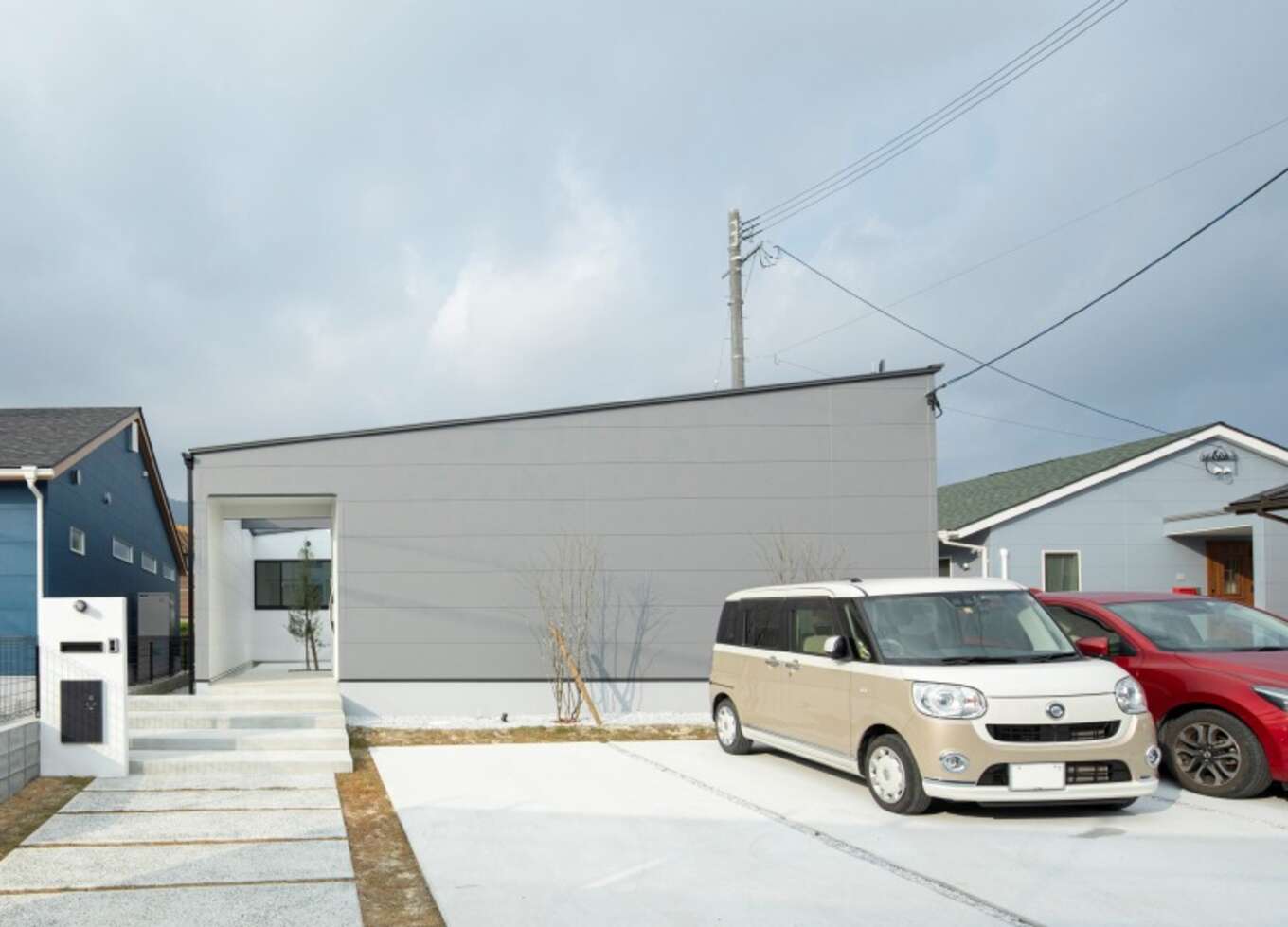 グレーの外壁の平屋と玄関アプローチ