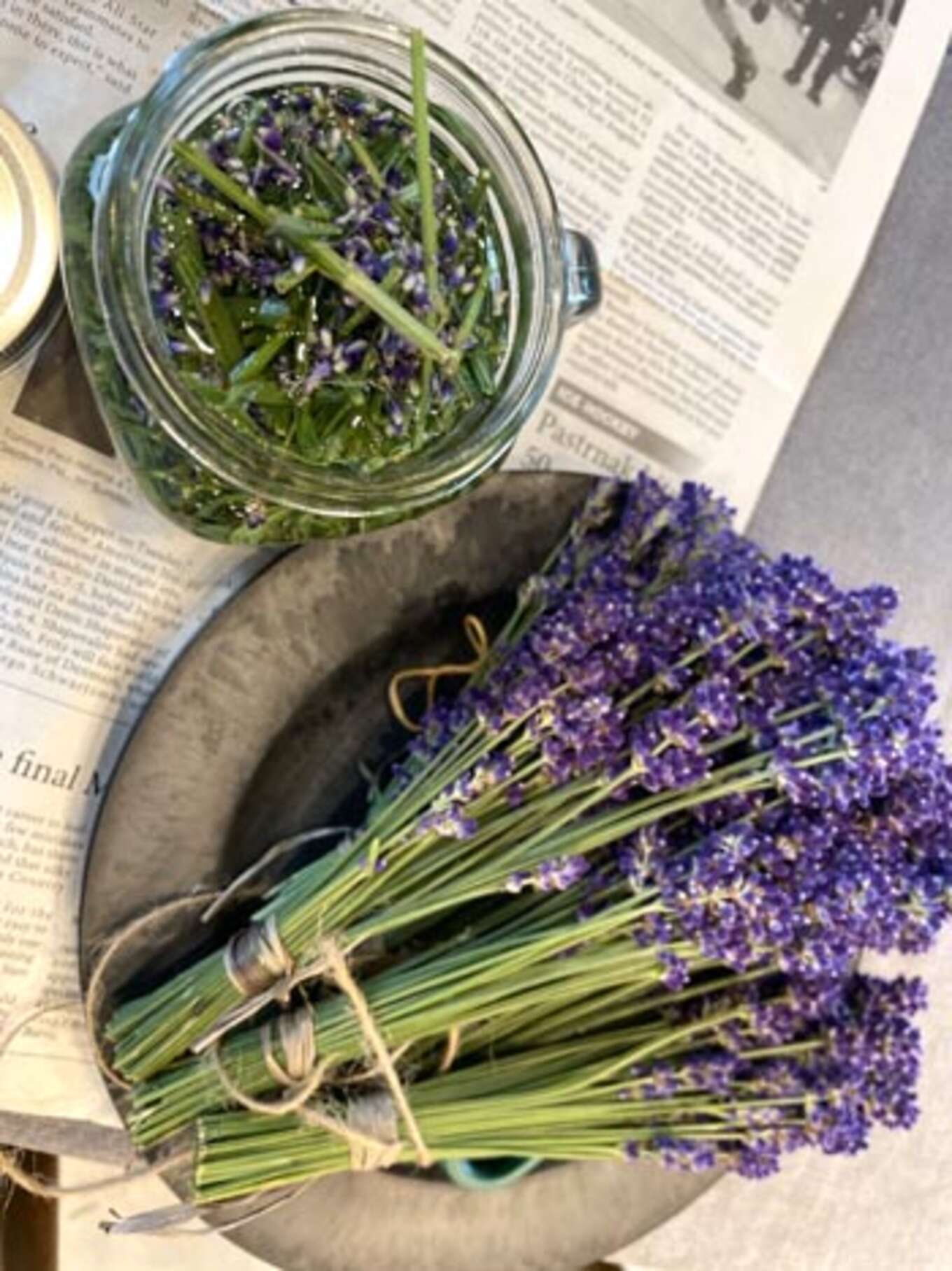 除かれたラベンダーの花や茎葉を入れた瓶の口いっぱいまでリカーを入れた様子。