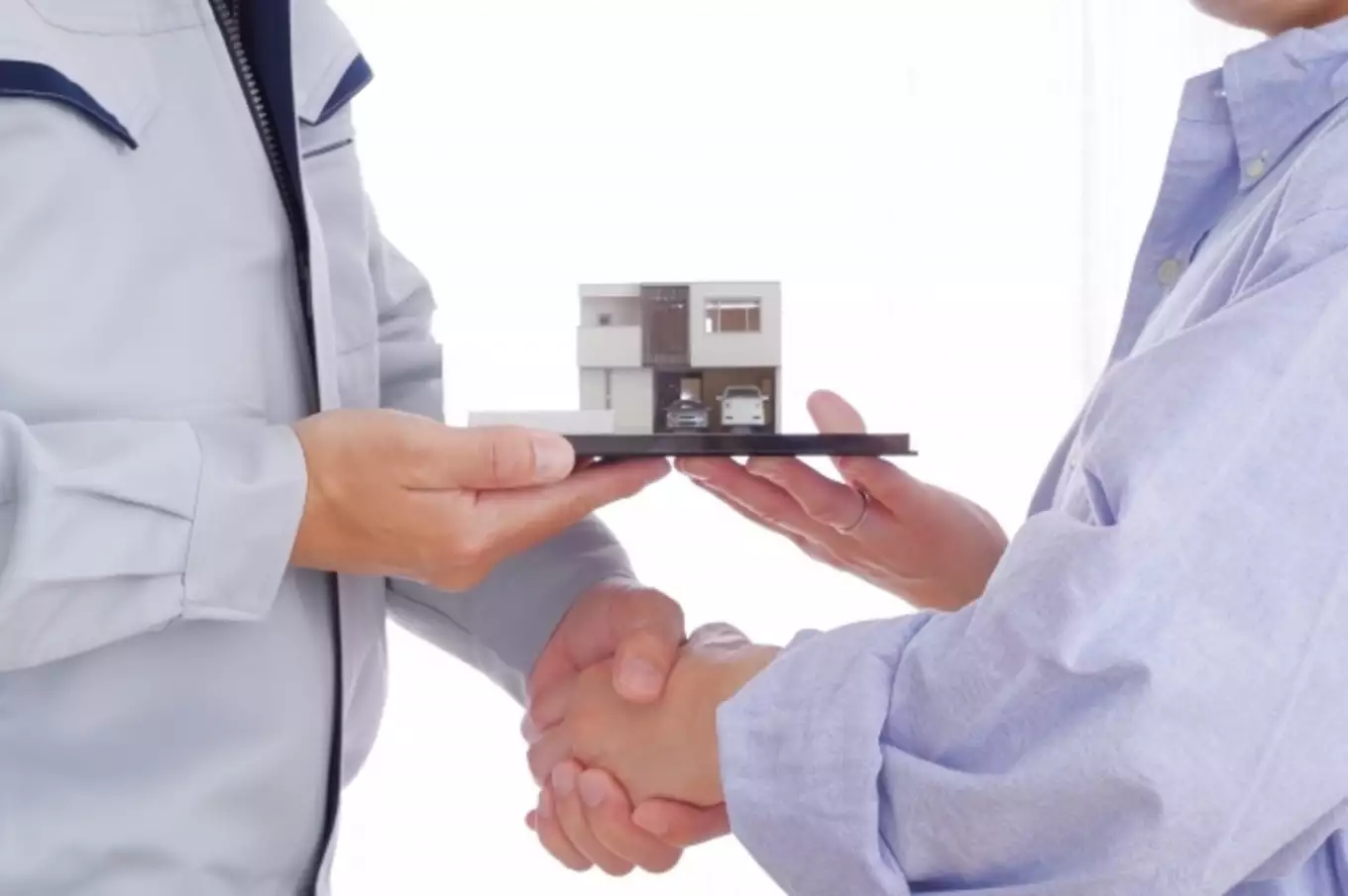 住宅模型、握手する男性2人
