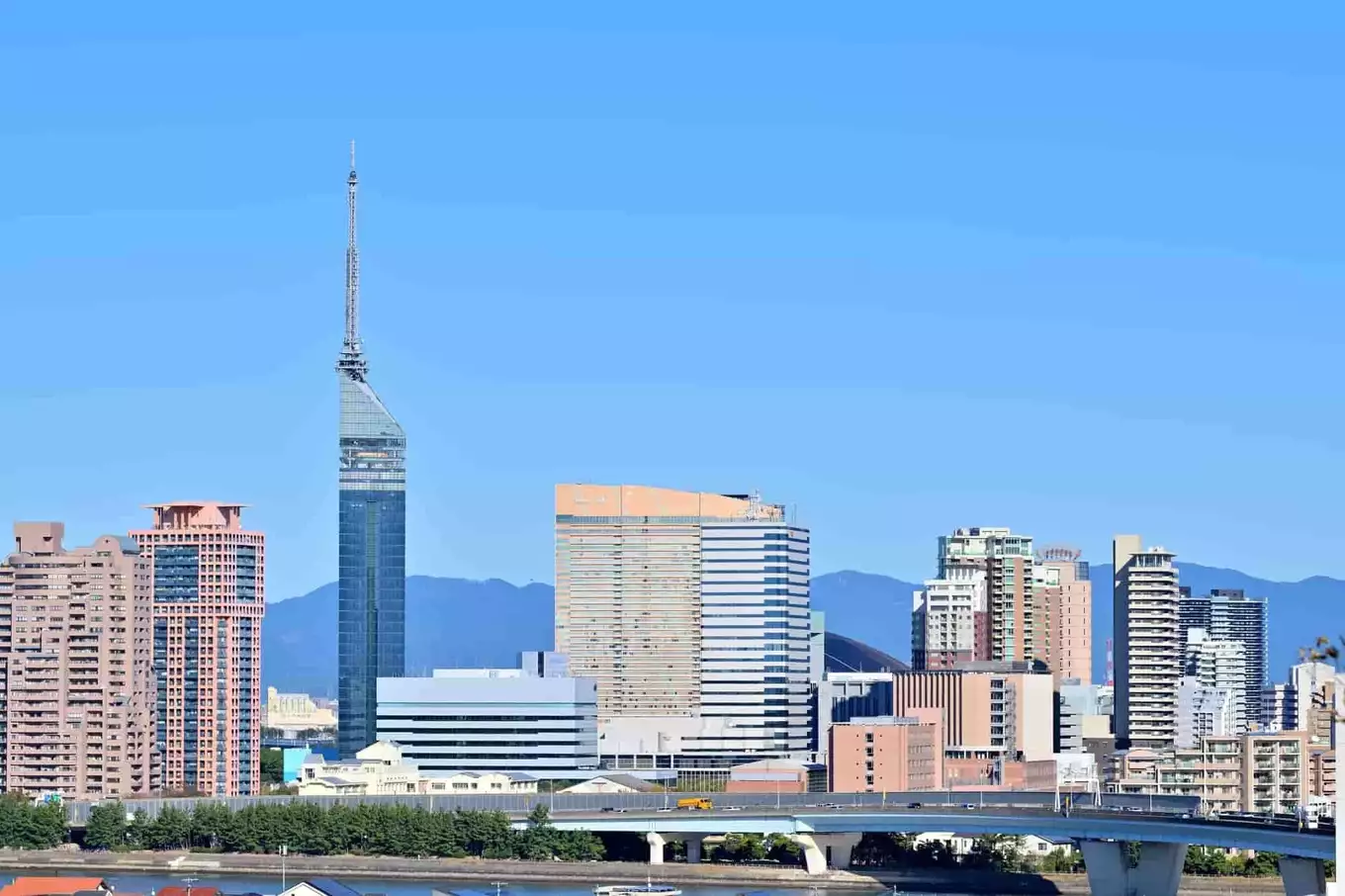 青空の下にビルが立ち並ぶ福岡市の風景