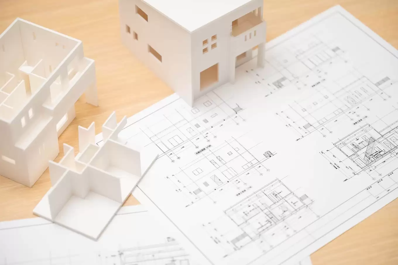 机の上に置かれた設計図面と住宅模型