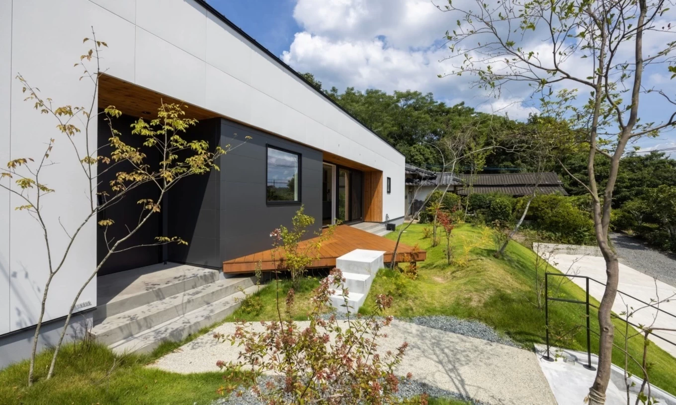 緑の芝生とウッドデッキが広がる開放的な庭