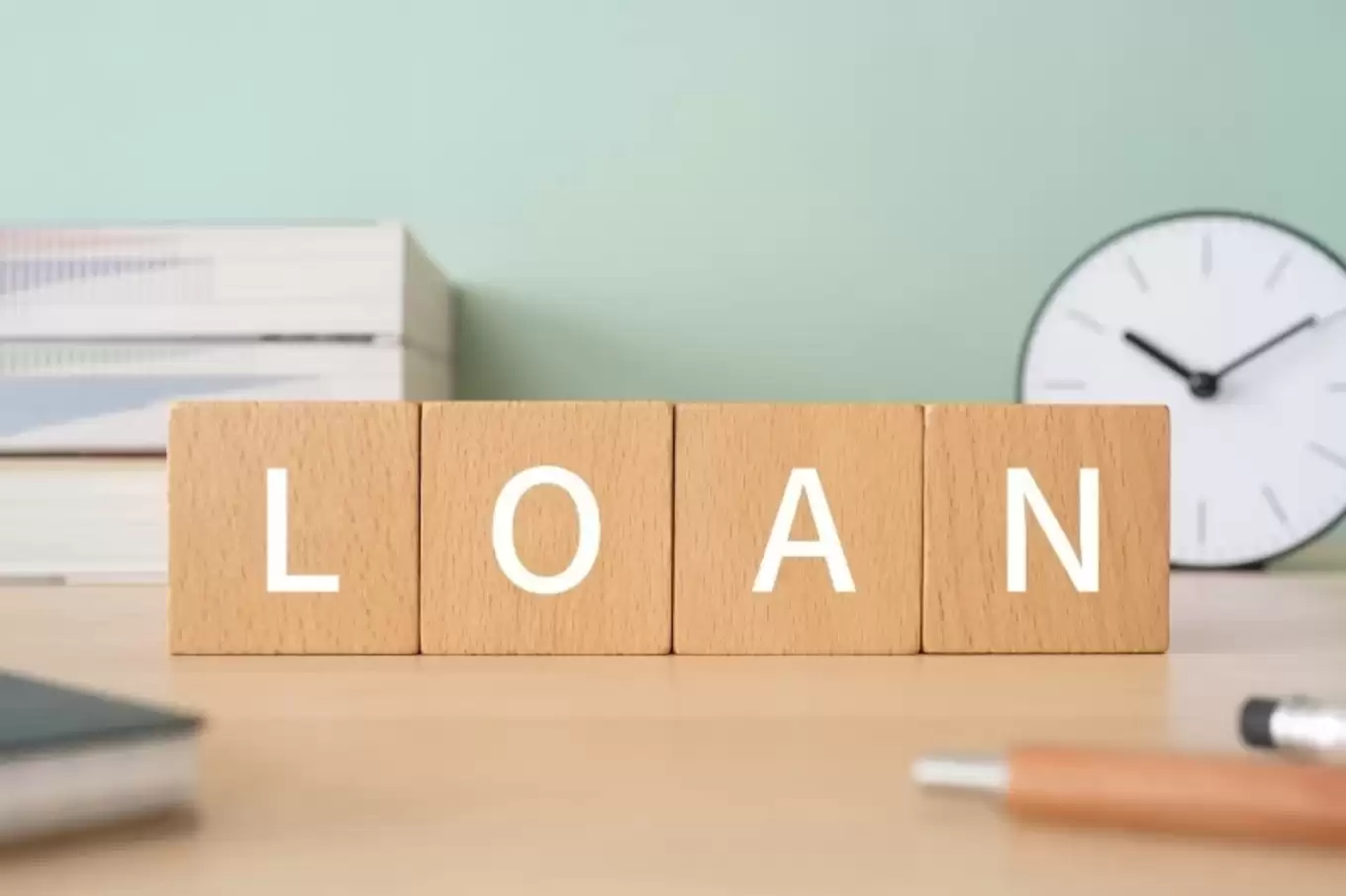 「LOAN」と書かれた積み木ブロックが置かれたデスク