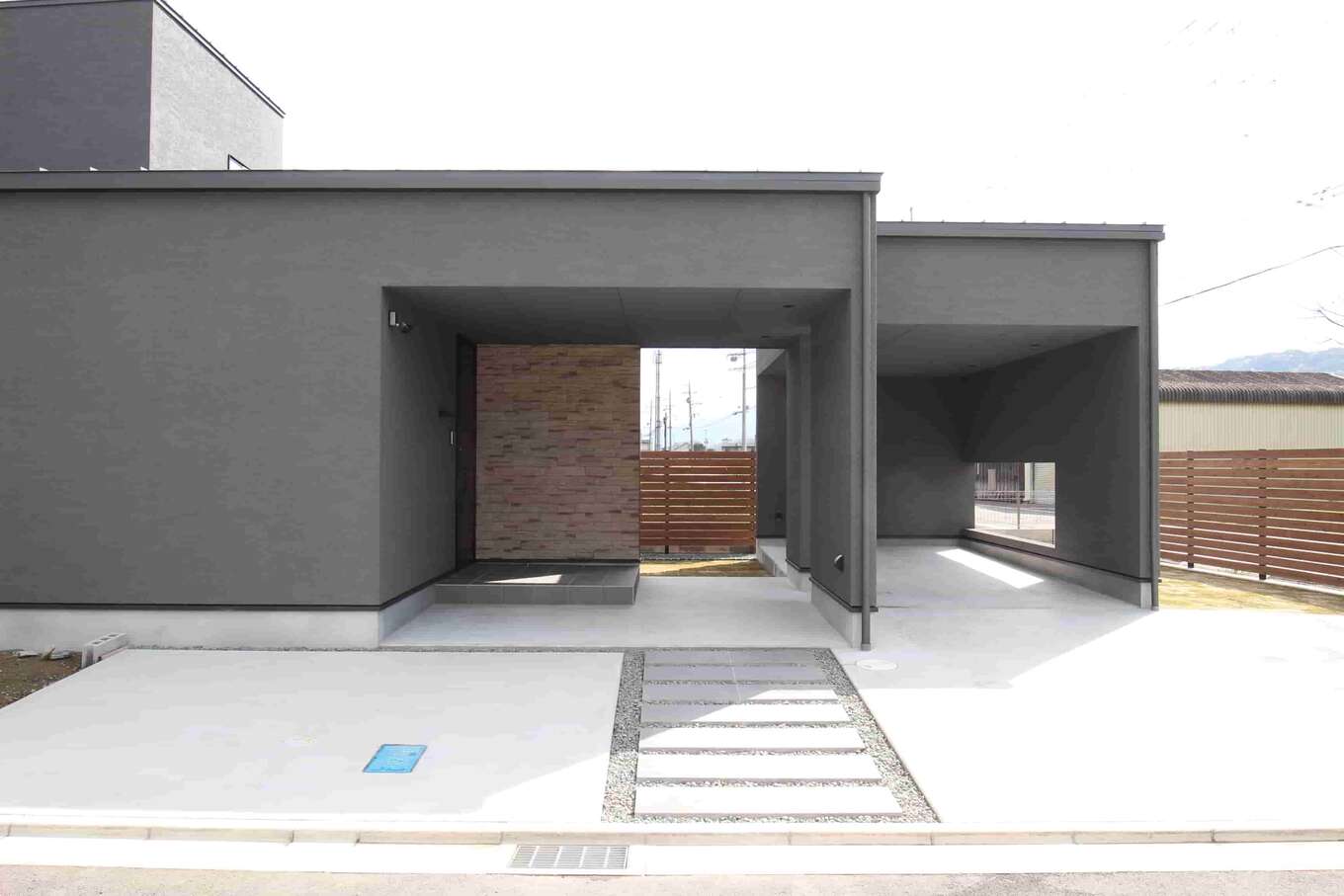 グレーの外壁とコンクリート平板の玄関アプローチ