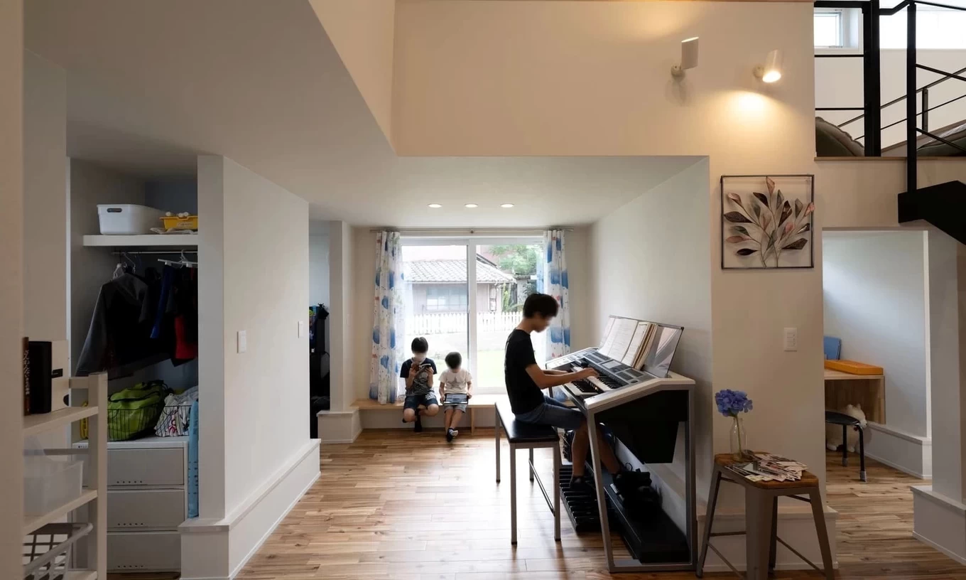 吹き抜けのリビングで電子ピアノを弾く家族の風景