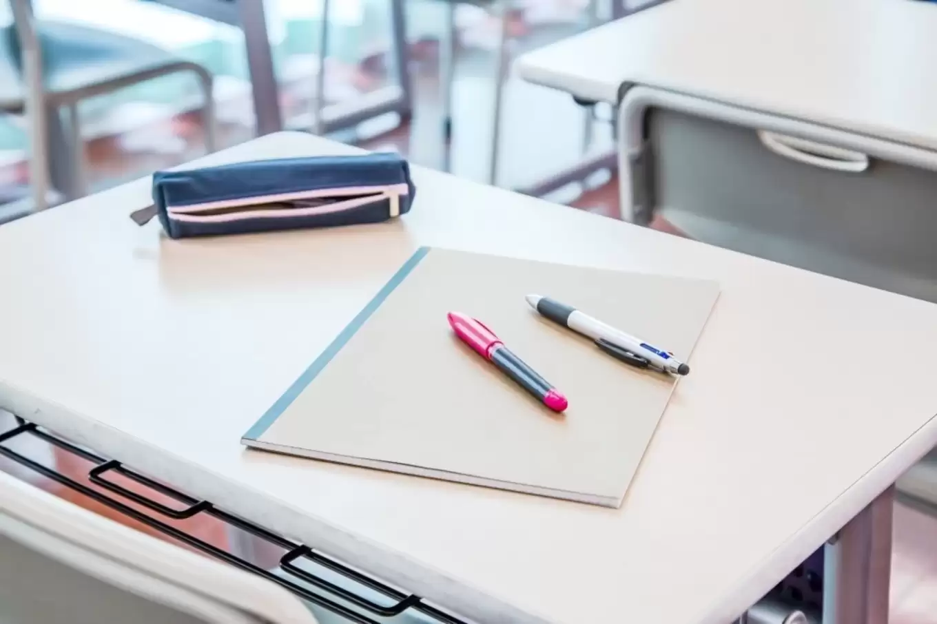 教室の机の上に置かれたノートとペン