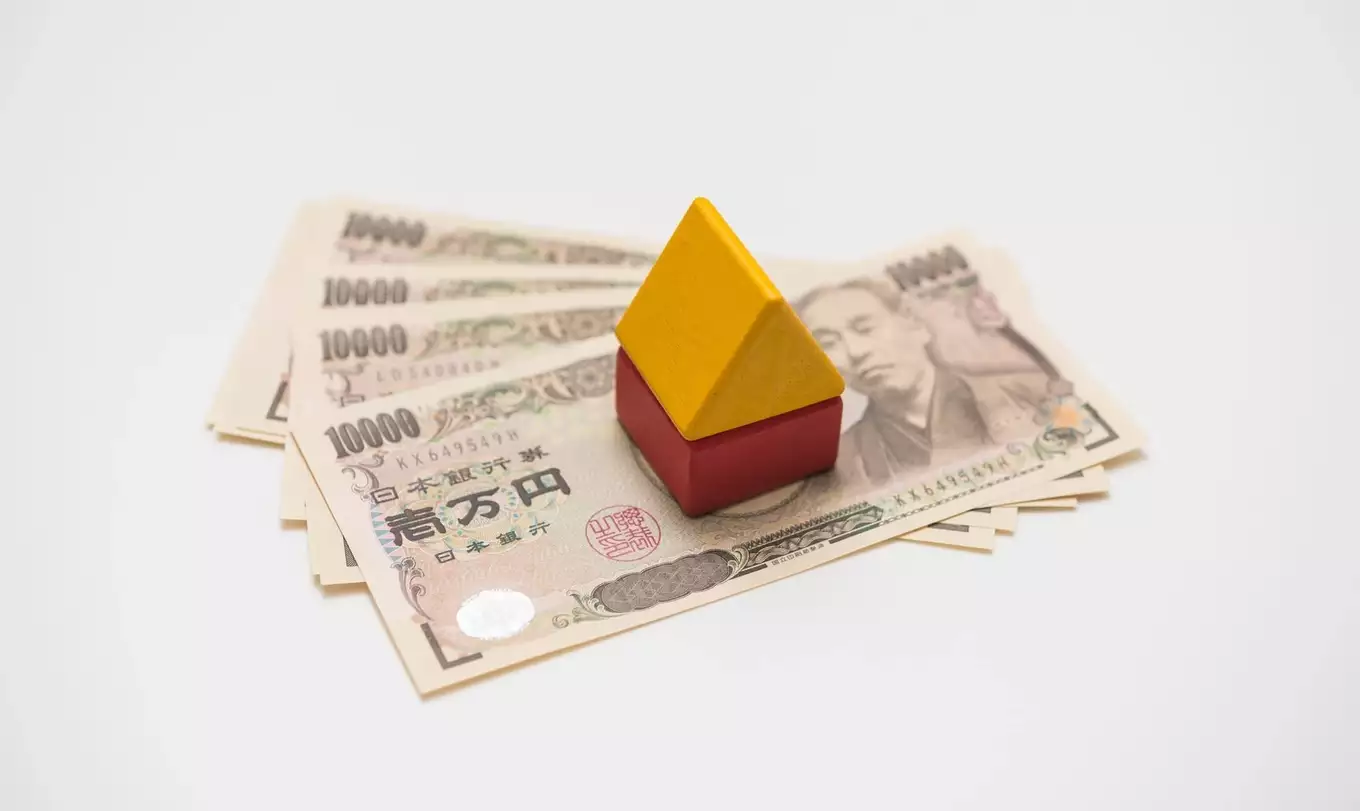 黄色と赤の家の模型とお金