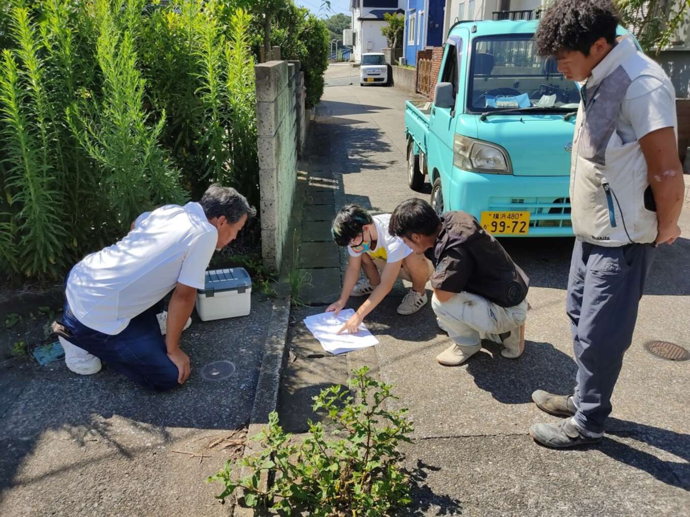 道路で打ち合わせ中の基礎屋さんと営業担当