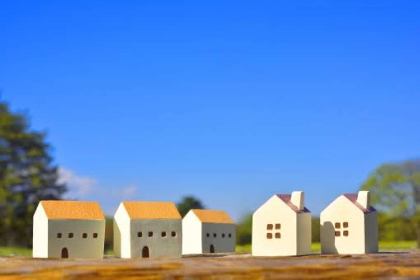 青空に並ぶオレンジ屋根の家の模型