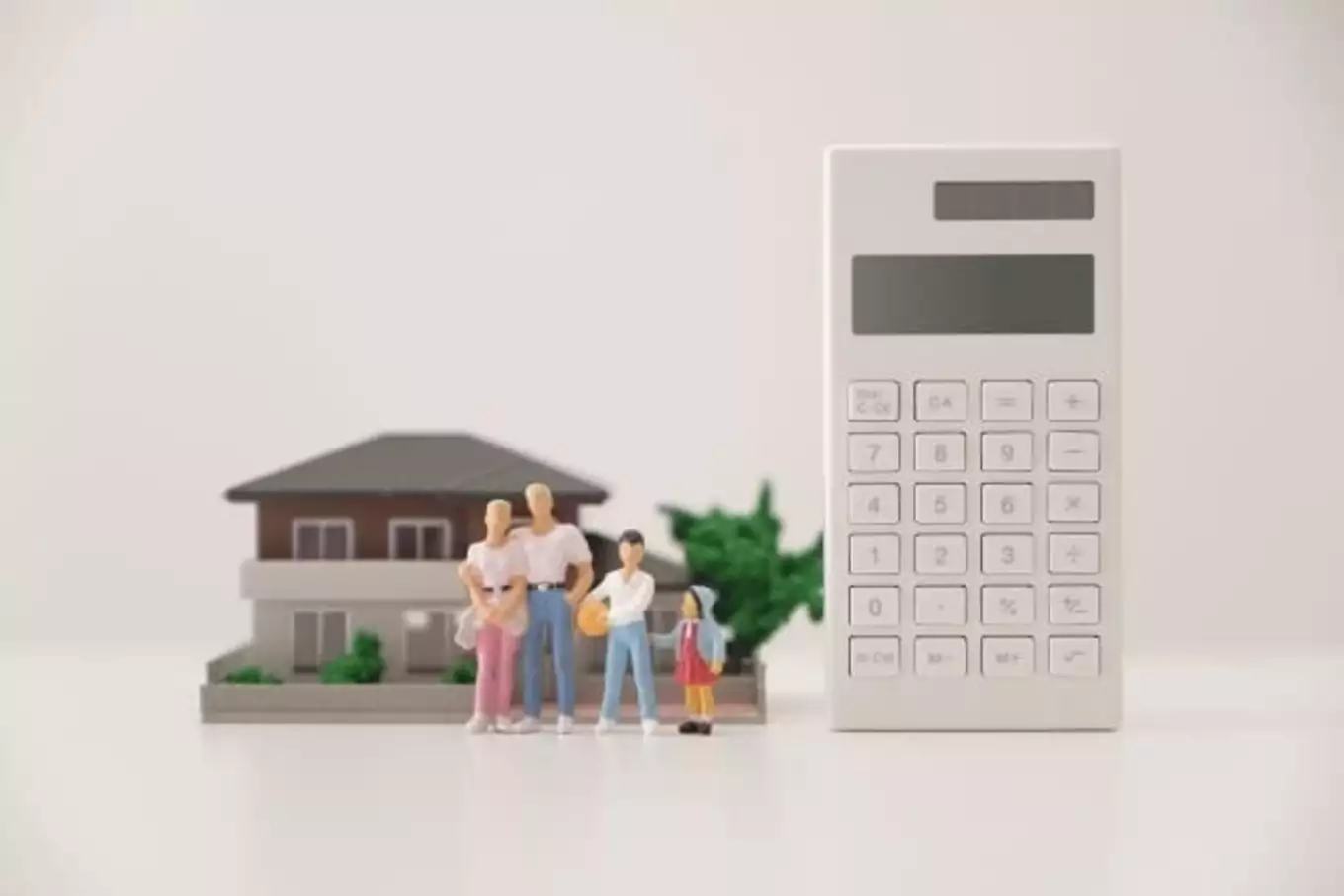 電卓と住宅模型と家族の人形