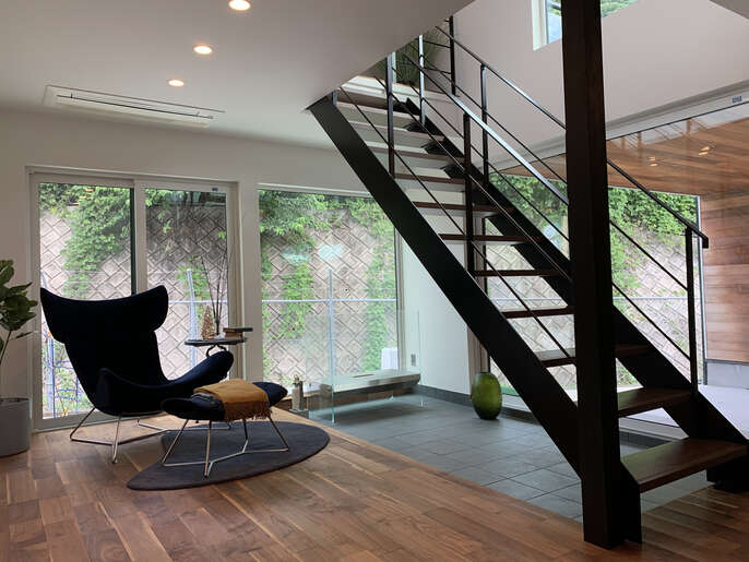 R+houseの施工事例写真です。土間空間を作ったリビングに2階へ繋がる鉄骨階段があります。