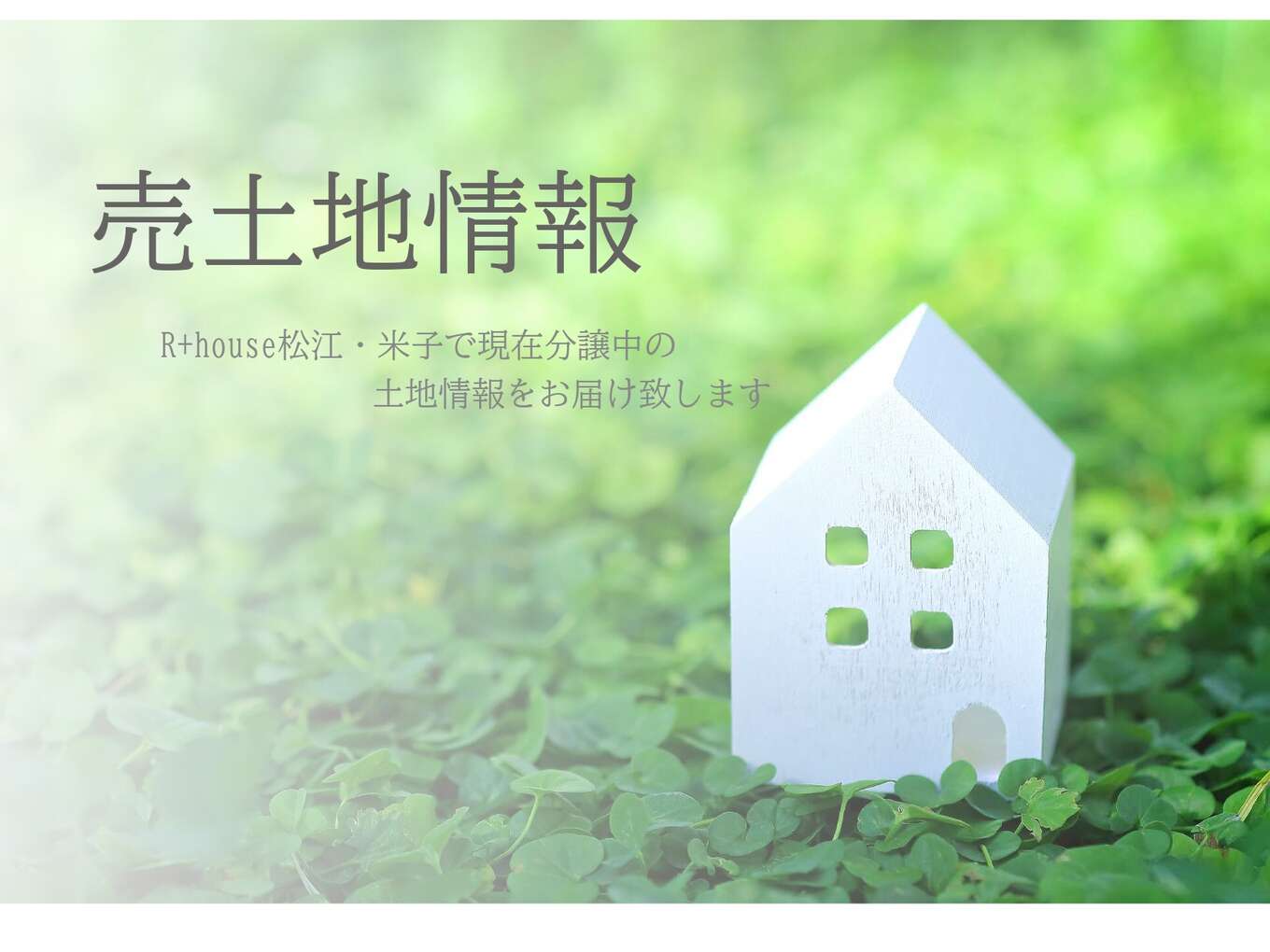 緑のなかにある白い家の模型