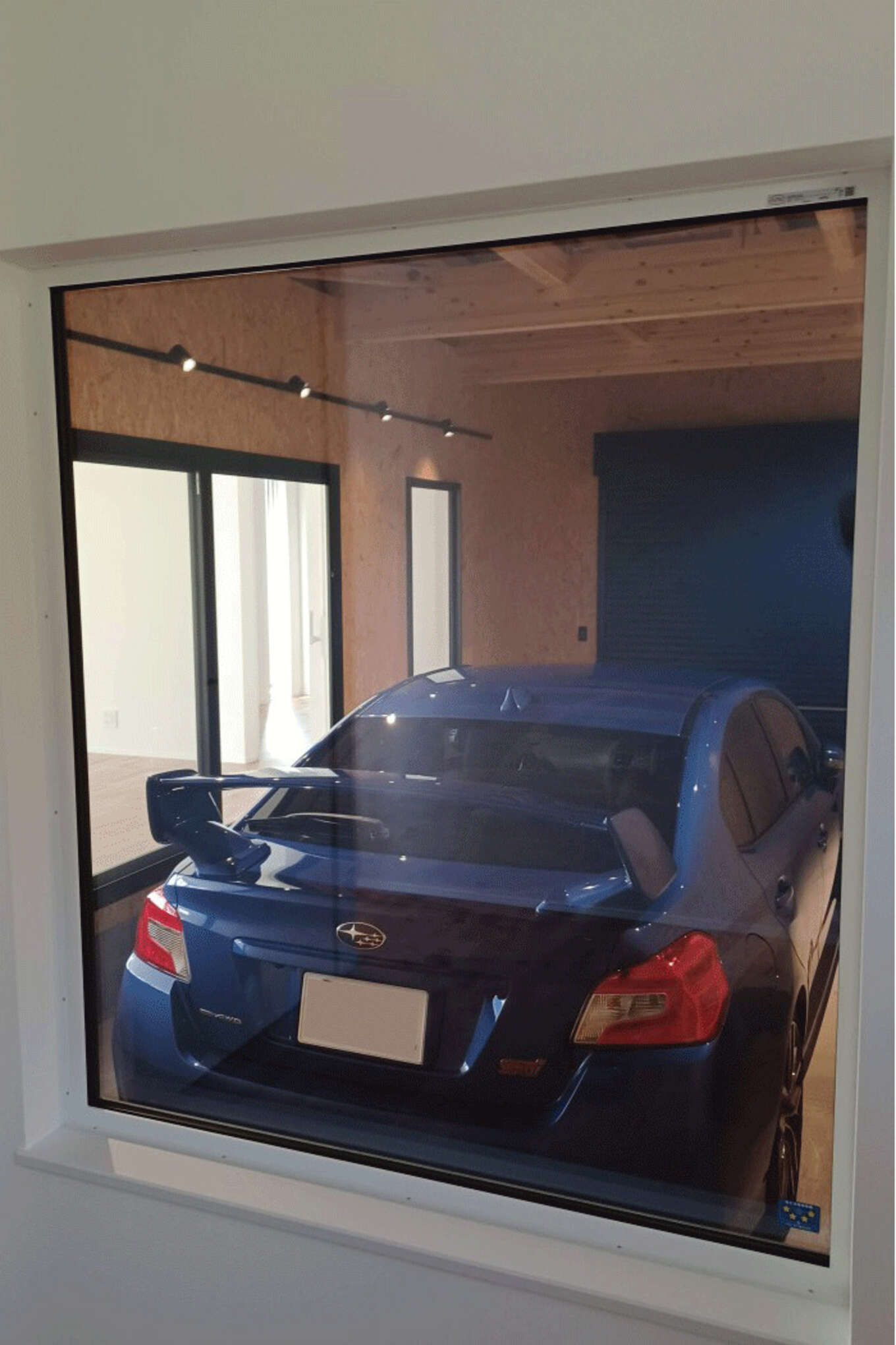 窓から見えるガレージの青い車