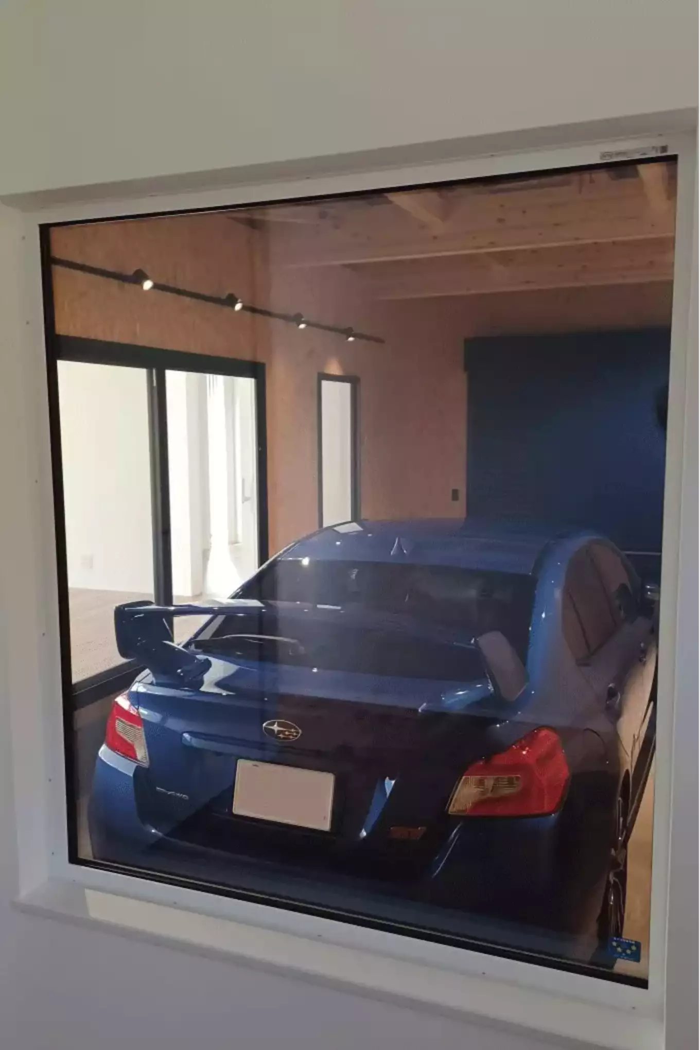 窓から見えるガレージの青い車