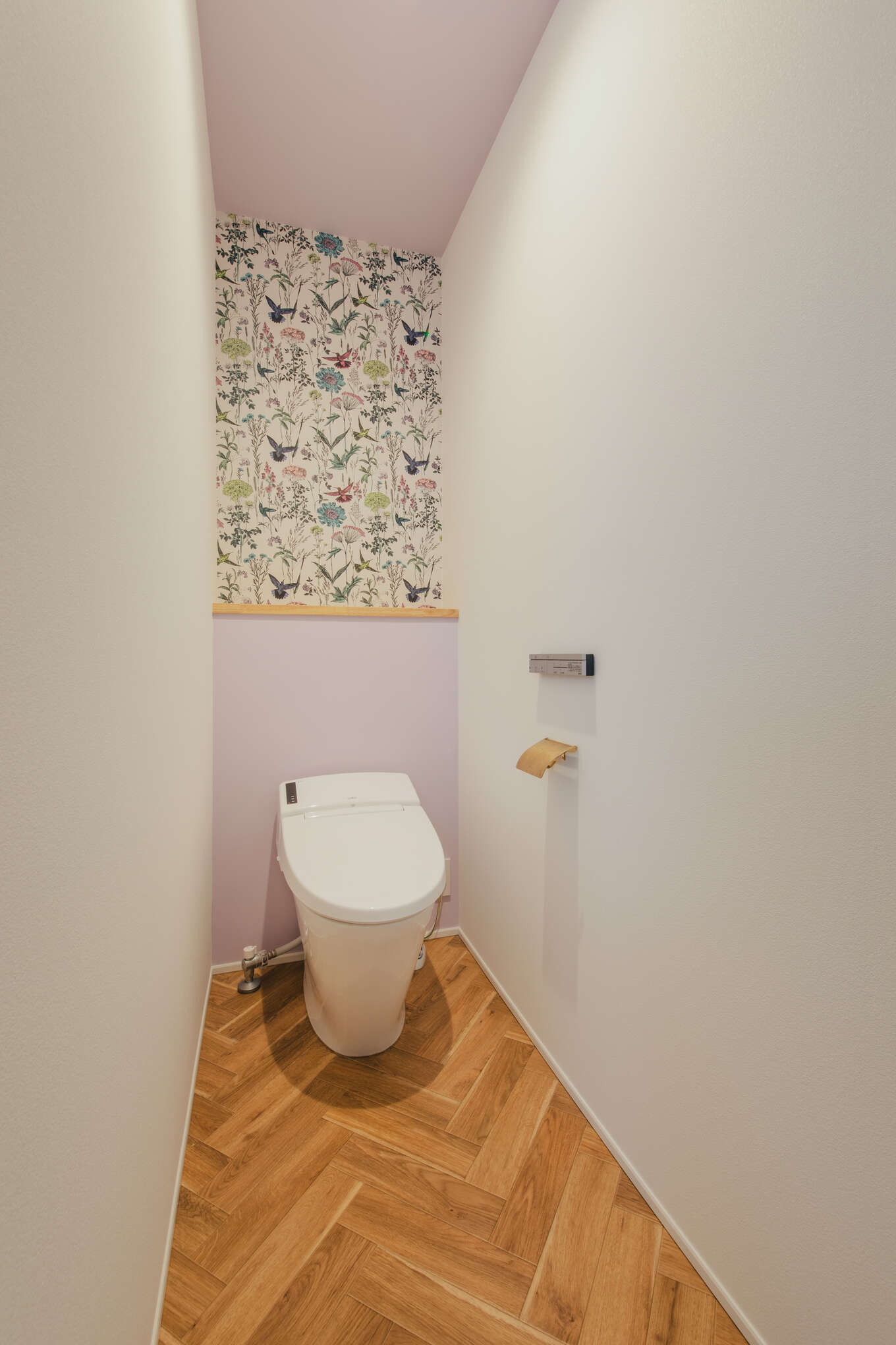 ボタニカルな壁紙とやさしい色合いのトイレ