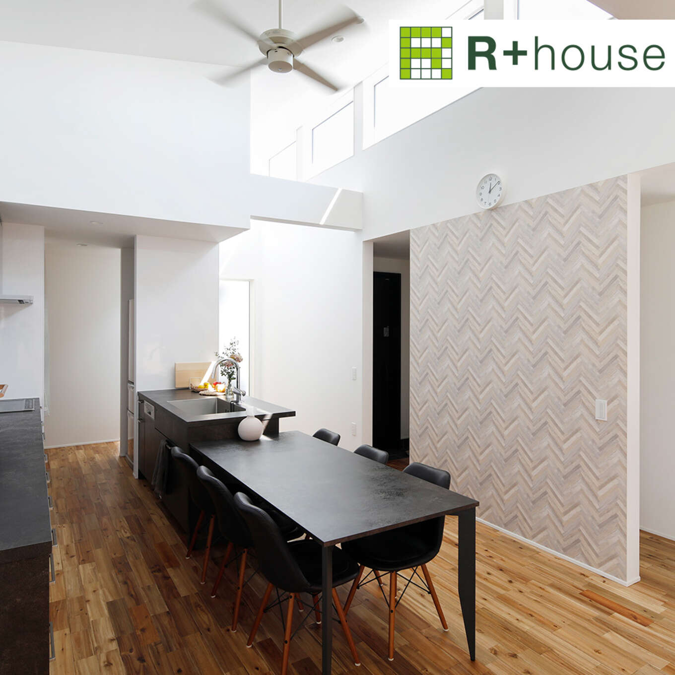 R+houseの物件のリビングダイニングの写真です。白が基調の室内に黒をメインにしたキッチンとダイニングテーブルが映えます。