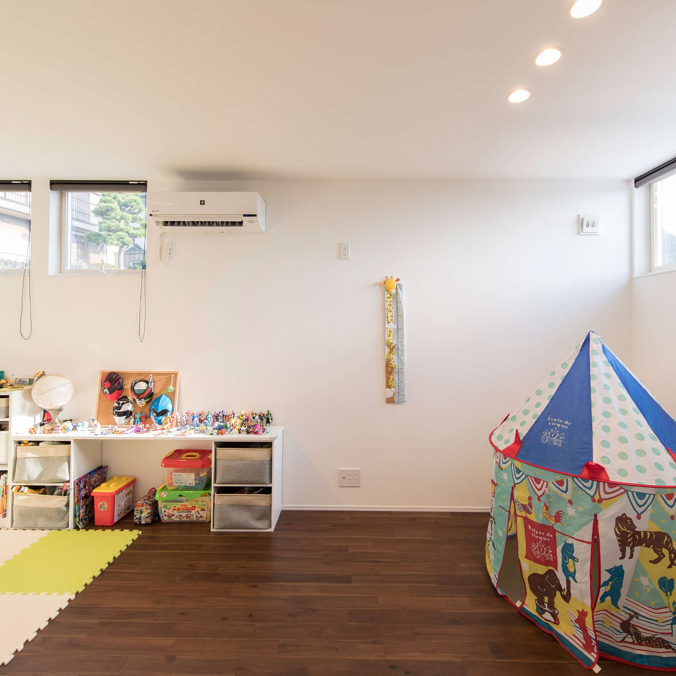 R+houseの物件の子ども部屋の写真です。濃いめのブラウンの無垢の床と白い壁と天井。高い位置に窓がある。