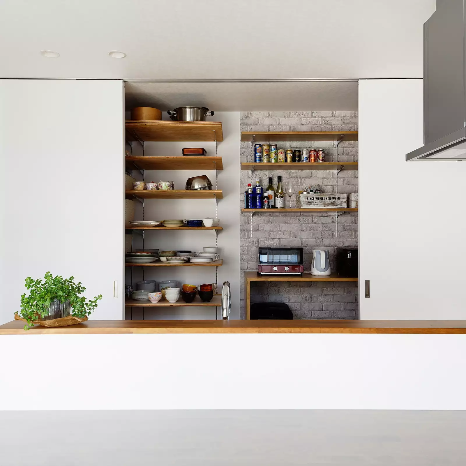 R+houseの物件のキッチンの背面収納の写真です。引き戸で隠したり見せたりできるおしゃれな収納