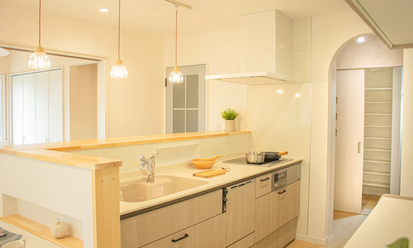 アーチ壁が魅せる北欧風の家(秋田県秋田市)の収納充実・カウンターキッチンの写真