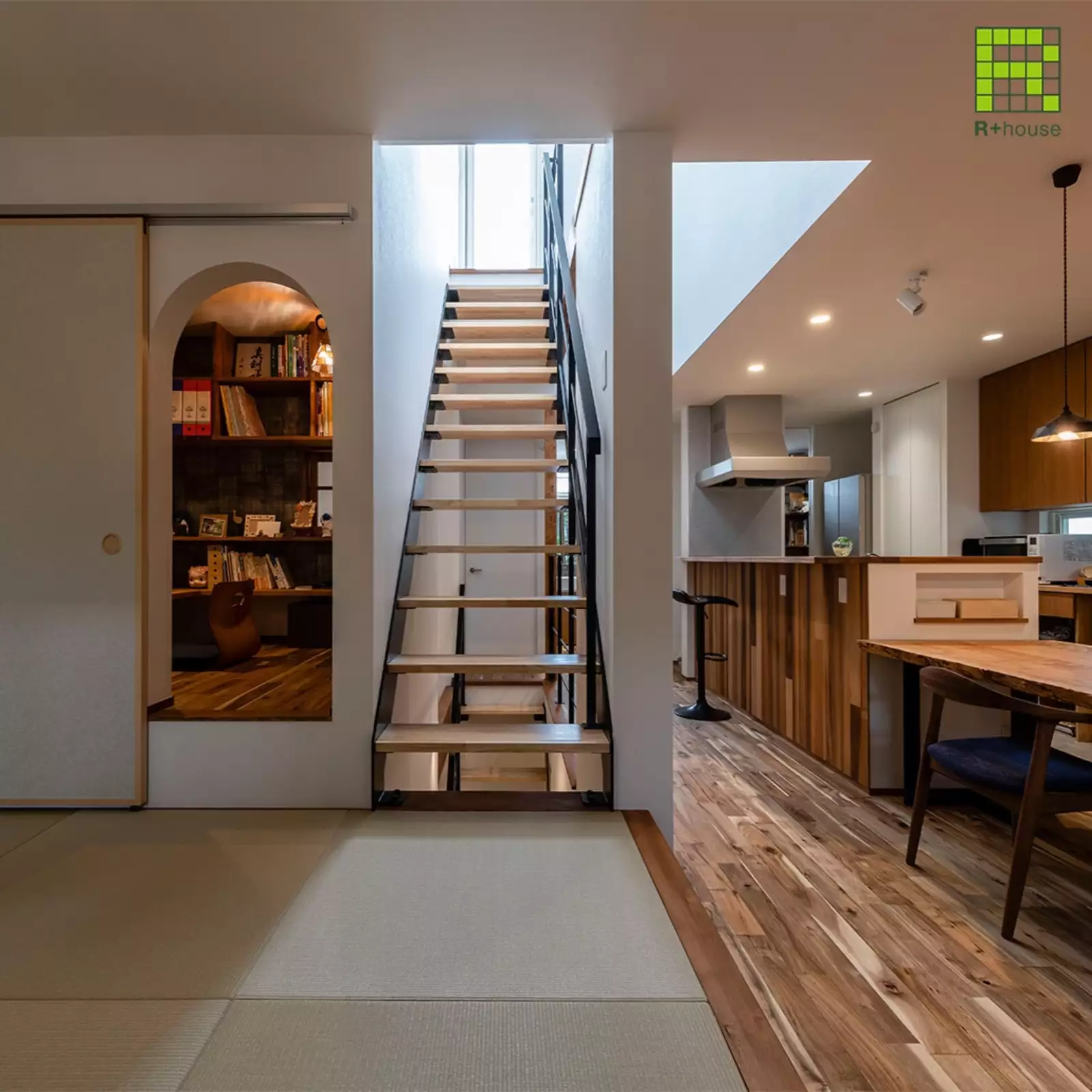 R+houseの物件の畳スペースの写真です。左側には小さめの書斎への入り口、横には階段右側にはダイニングキッチンがある。