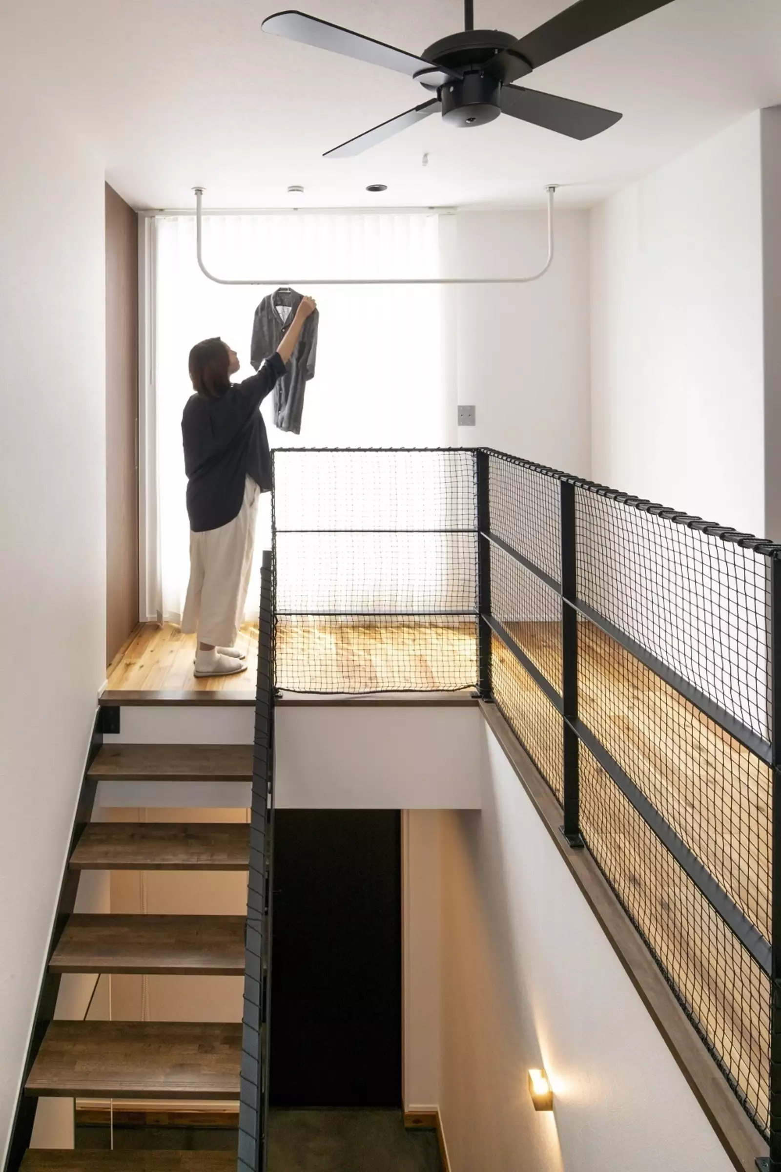 階段上のスペースを室内干しできるように活用した折り畳み式の物干しレバー