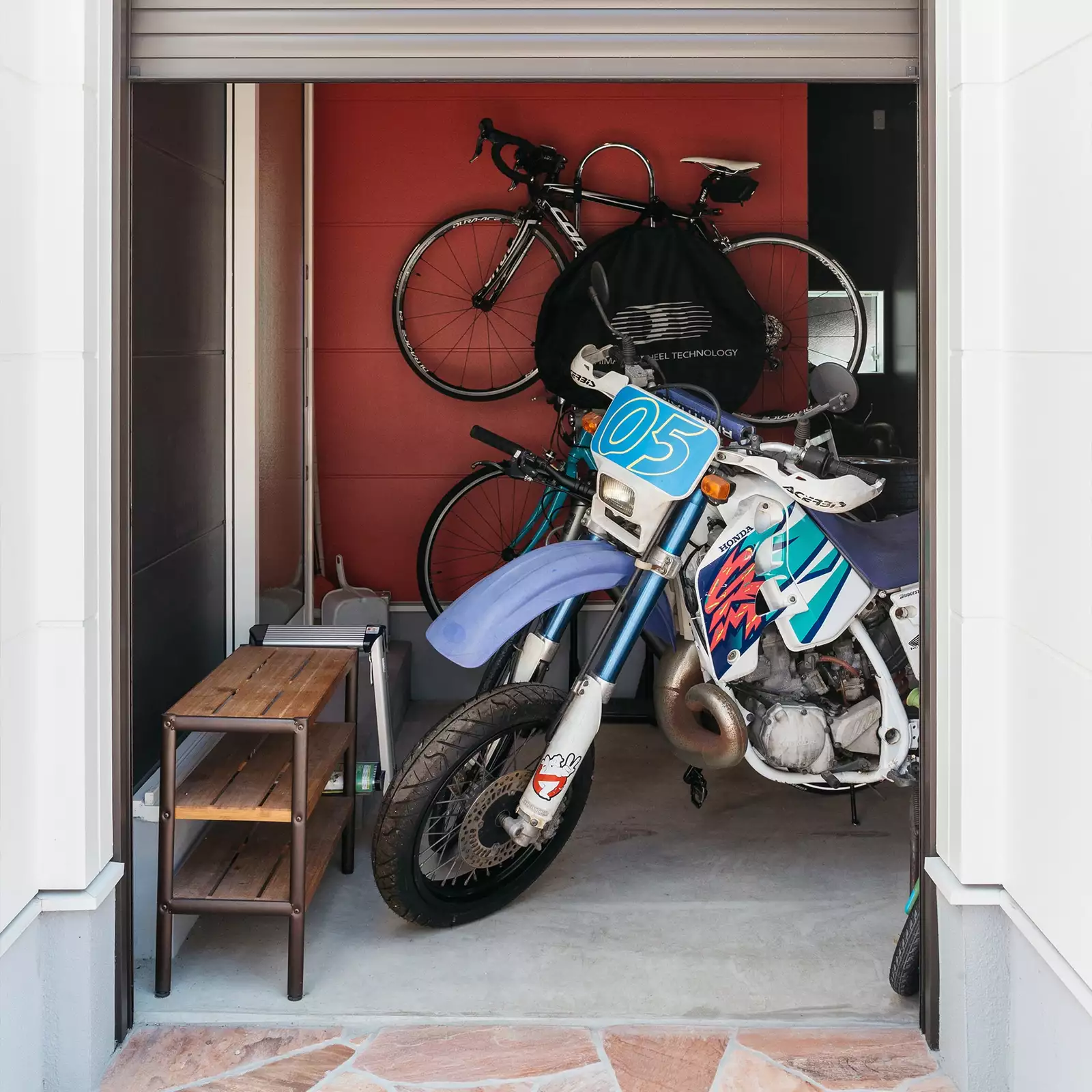 R+houseの物件のバイクガレージの写真です。バイクや自転車が出入りできるぐらいの大きさのシャッターで閉まるアーチ状の出入り口。