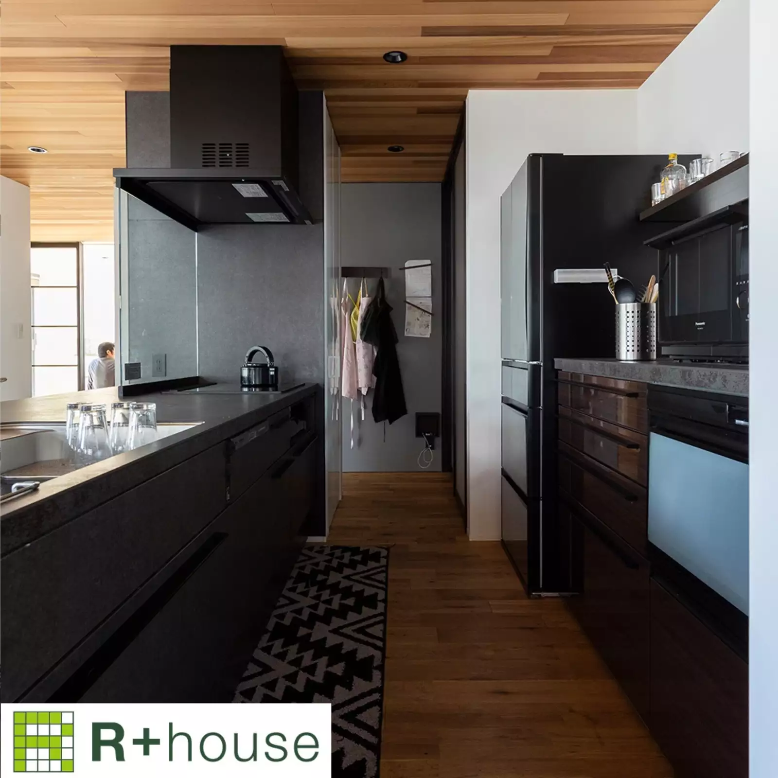 R+houseの物件のキッチンの写真です。手前にはオープンキッチン、奥にはパントリーや洗面浴室につながる