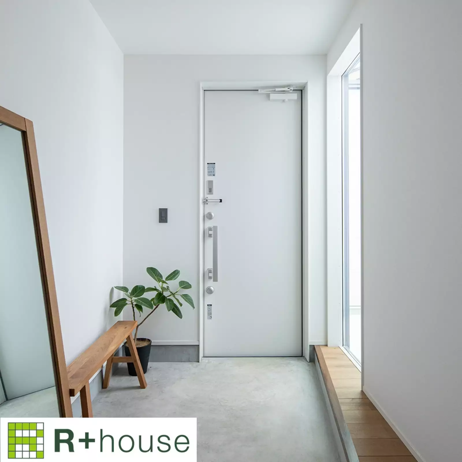 R+houseの物件の玄関の写真です。白を基調とした玄関。大きな窓があり明るい空間