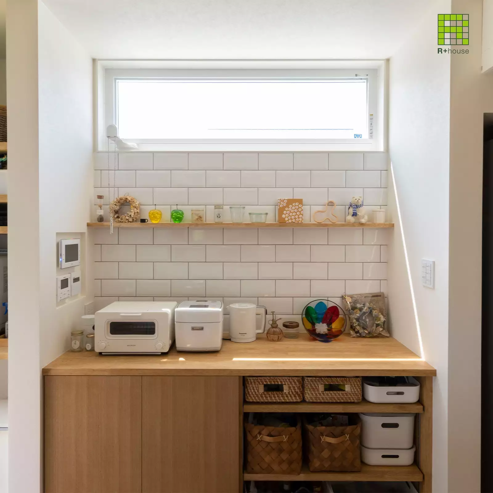 R+houseの物件のキッチンの棚の写真です。上部に横長の窓。壁は白タイルにしてお気に入りの小物を並べられるオープンな棚を。