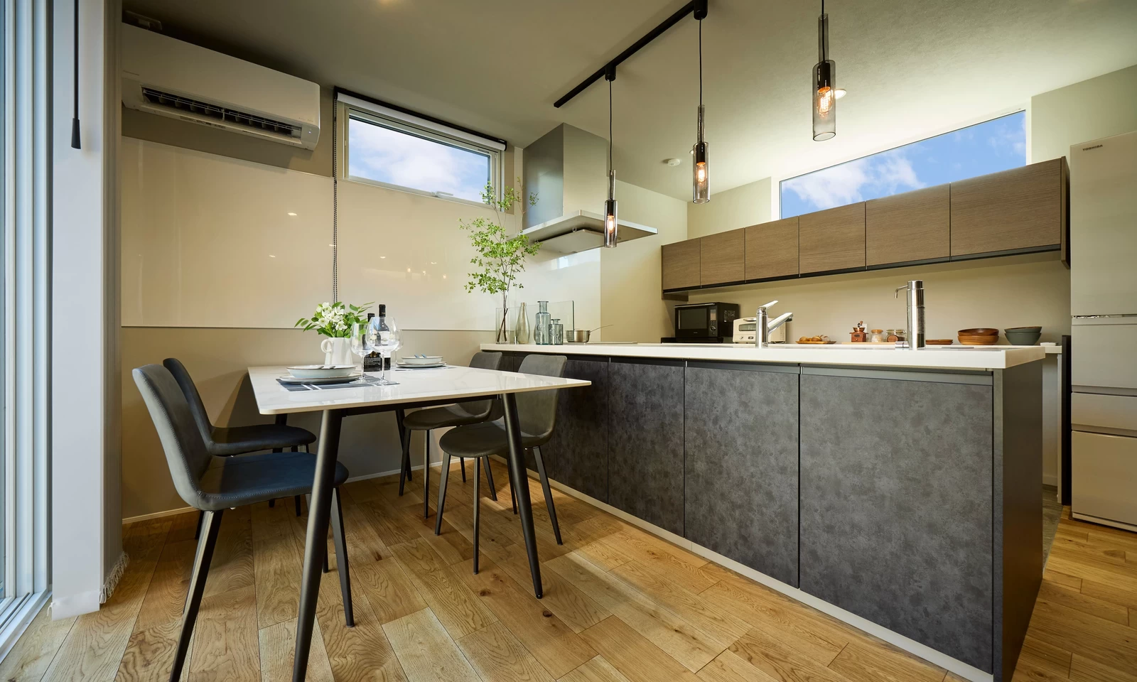 プライバシーに配慮した中庭のある家(秋田県秋田市)のグレーのキッチン・対面キッチンの写真