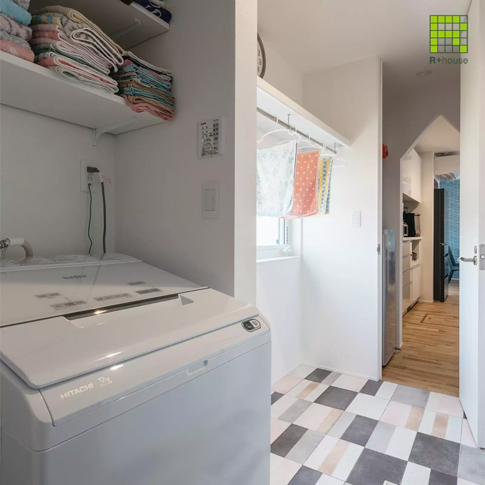 R+houseの物件の脱衣室の写真です。洗濯機と室内干し用のポールを設置してある。