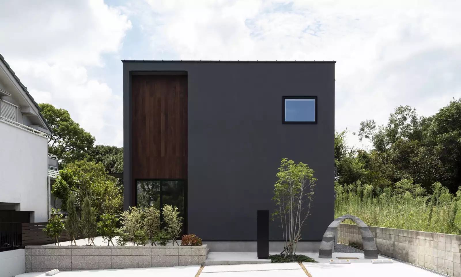 植栽のある黒いキューブ型の家