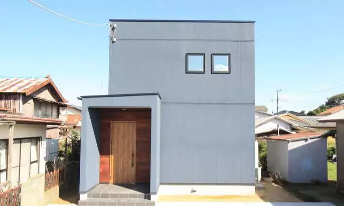 グレー色の吹き付け塗装の外壁とレッドシダー張りの家