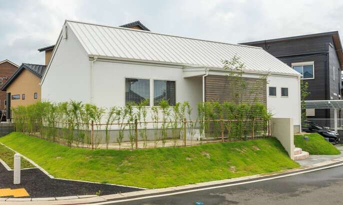 R+houseの物件の写真です。屋根も壁も真っ白な家。周りに植えられた緑がおしゃれ