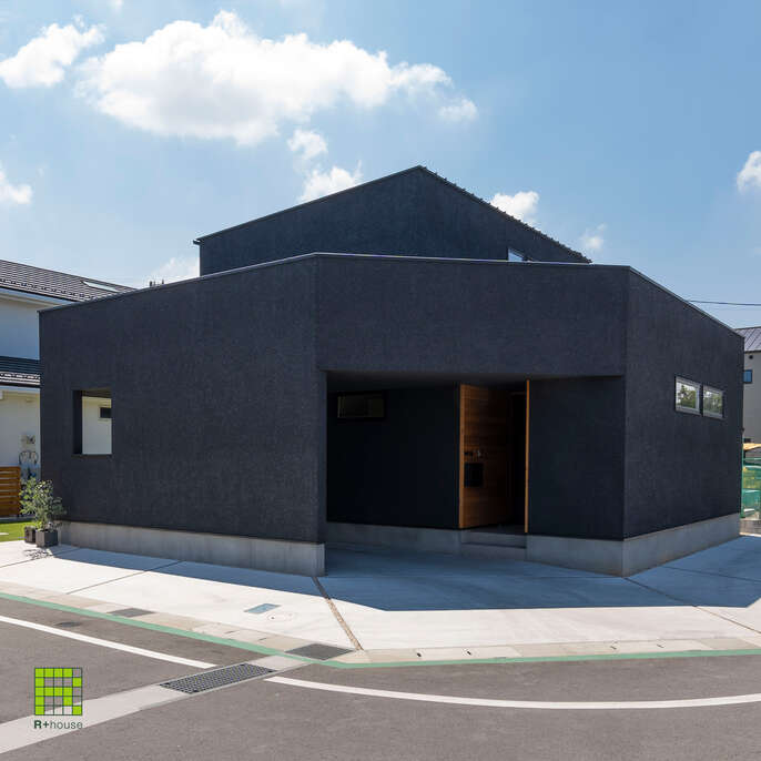 R+houseの物件の写真です。黒色の外観のビルトインガレージがある二階建てのお家